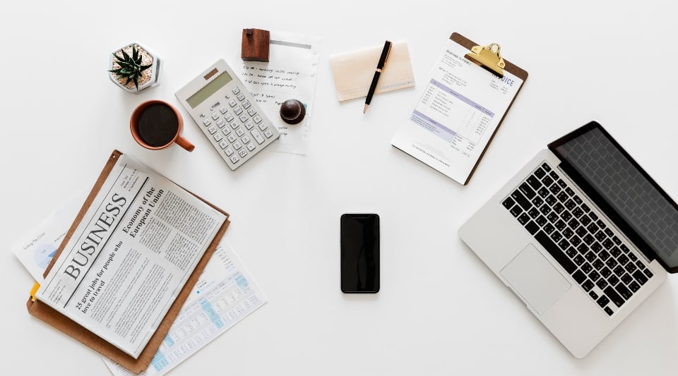 Professional bookkeeper emplyed with Rockel Bookkeeping, LLC in Martin County Florida. Showing example of Bookkeepers desk with financial documents and calculator